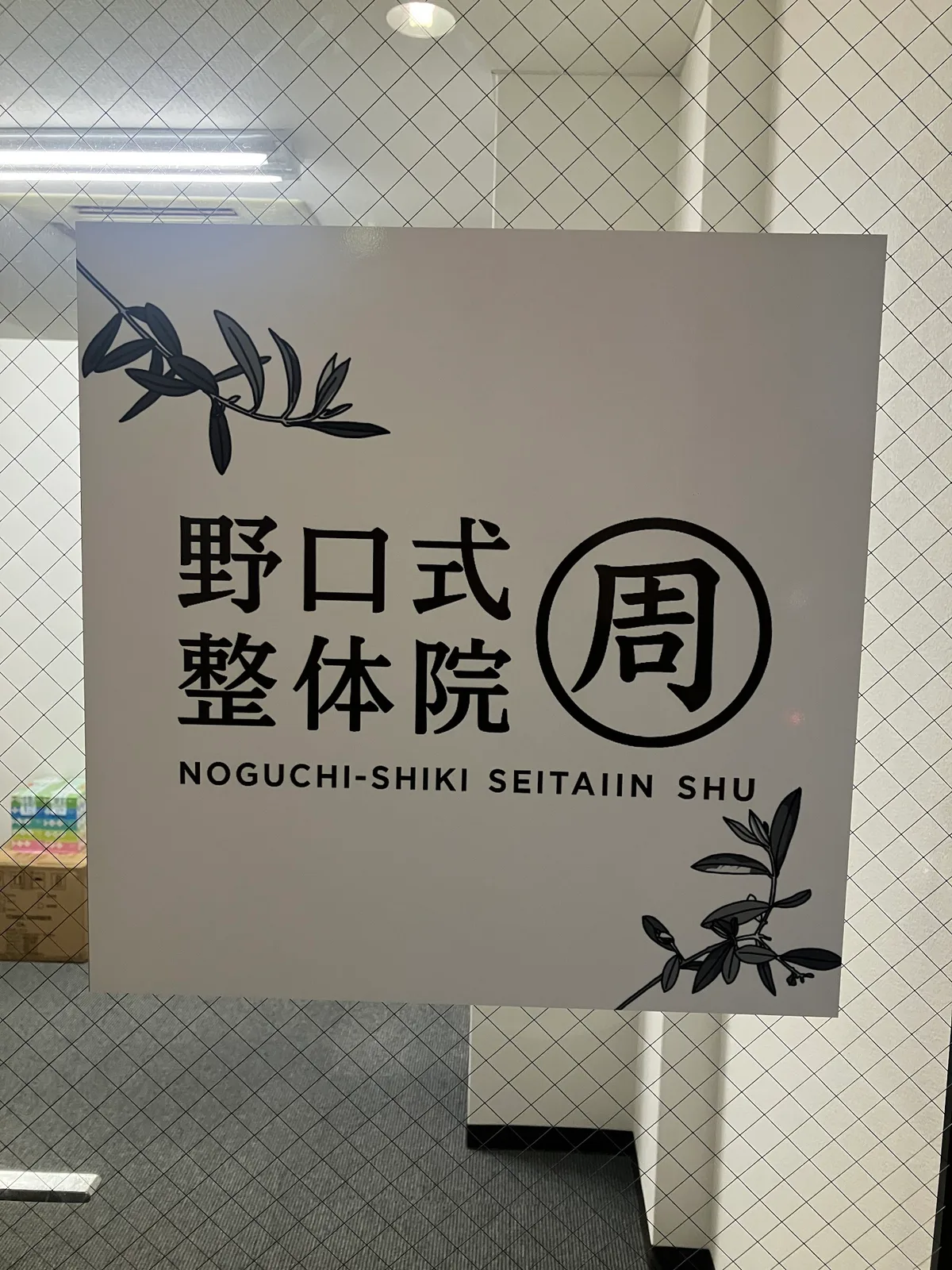 7階のフロアに掲げられた「野口式整体院 周」のロゴ看板